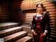 A woman in a red leather outfit standing on some steps.