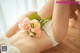 A woman laying on the floor holding a bouquet of flowers.