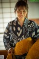 A woman in a kimono smiles at the camera.