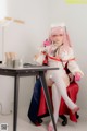 A woman in a nurse outfit sitting at a desk.