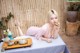 A woman in a pink dress sitting at a table with a cup of tea.