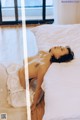 A woman laying on a bed with a tattoo on her back.