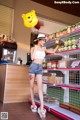 A woman standing in front of a store holding a yellow balloon.