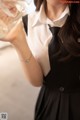 A woman in a black dress holding a glass of water.