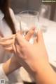 A woman holding a glass of water in her hands.