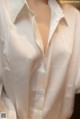 A woman wearing a white shirt with a plunging neckline.