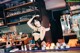 A woman in lingerie standing behind a bar.