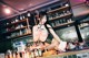 A woman in lingerie sitting at a bar.