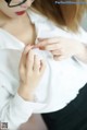 A woman wearing glasses and a white shirt.