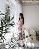 A woman standing in front of a window in a room.