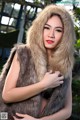 A woman in a fur vest posing for a picture.