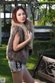 A woman in a fur vest posing for a picture.