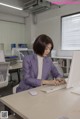 A woman sitting at a desk using a computer.