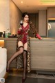 A woman in a leopard print robe holding a glass of wine.