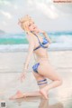 A woman in a bikini posing on the beach.