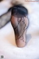 A close up of a woman's legs in black fishnet stockings.