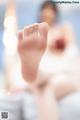 A close up of a woman's foot in a white dress.