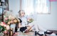 A woman sitting on the floor in a room with flowers.