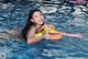 A woman in a swimming pool with an inflatable ring.