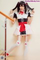 A woman in a maid outfit posing for a picture.