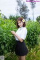 A woman in a white shirt and black skirt posing for a picture.