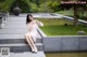 A woman in a white dress sitting on some steps.