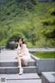 A woman in a white dress sitting on some steps.