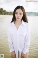 A woman in a white shirt standing in the water.