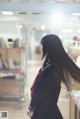 A woman in a school uniform standing in a room.