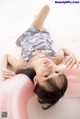 A little girl laying on top of a pink inflatable ring.