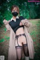 A woman wearing a face mask and stockings in the woods.