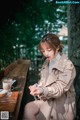 A woman sitting at a table with a cup of coffee.