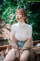 a woman sitting on top of a wooden bench