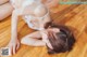 A woman laying on the floor in a white lingerie.