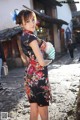 A woman in a black dress holding a fan.