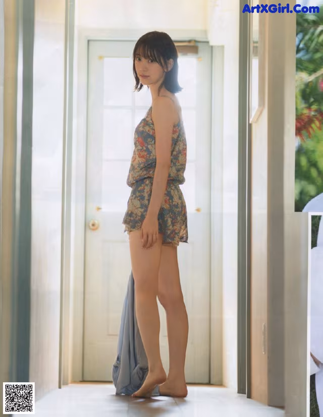A woman standing in front of a door in a room.