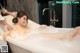 A woman taking a bath in a bathtub with foam.